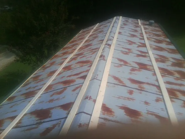 Rusted metal roof panels with new wood purlins before replacement — Storm Damage Roof Repair in Sachse by Roofing Brothers