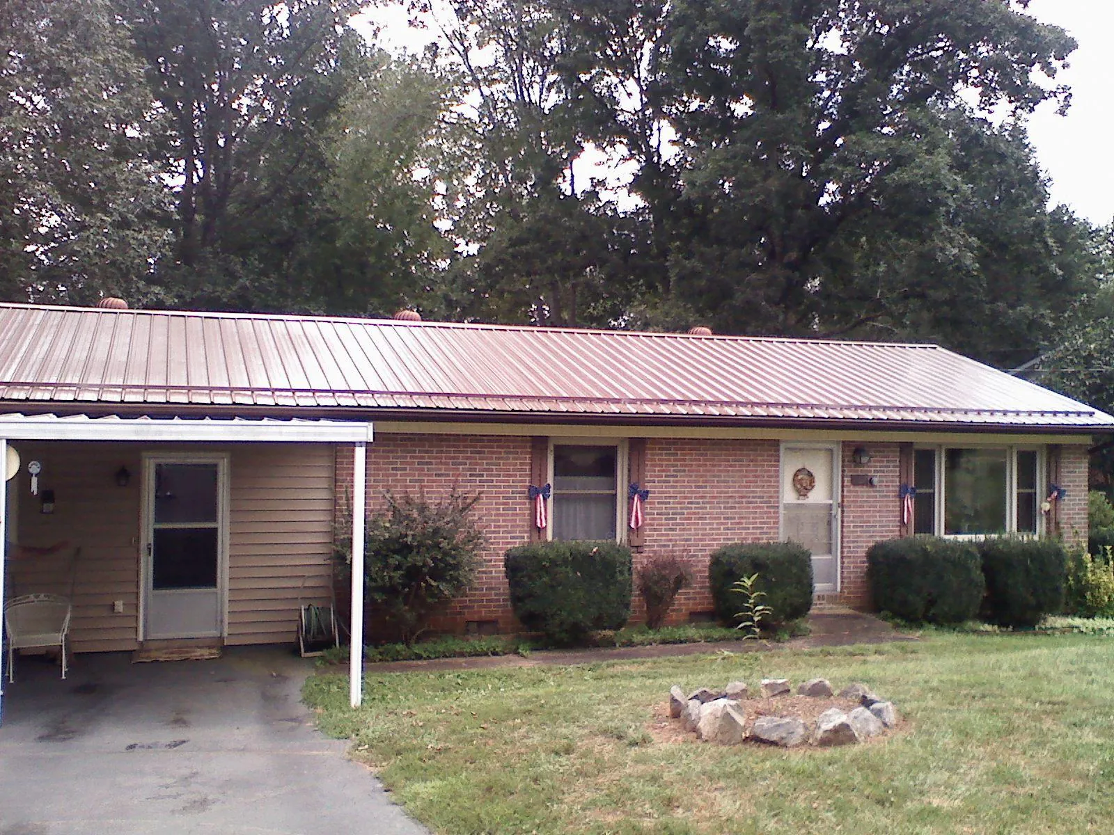 Bronze metal roof and carport on a brick ranch home — Roof Repair work by our crew in Sachse